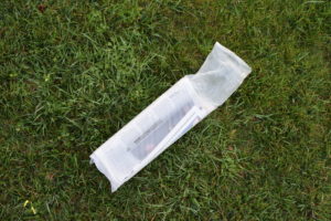 Newspaper, in plastic bag, on lawn