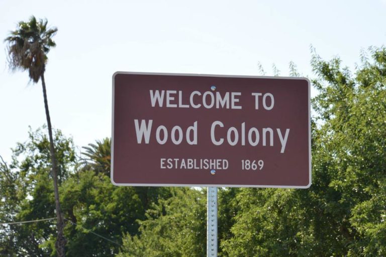 Sign reading "Welcome to Wood Colony"